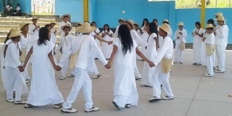 Muestra niños indignas danzando en el colegio