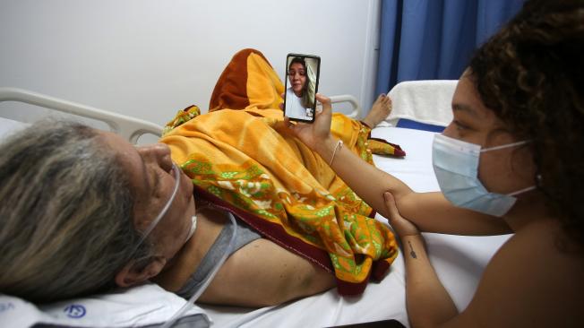 Lorena hace una videollamada junto a su madre, para hablar con su hermana mayor quien ya superó el virus y se recupera en casa. Foto: Juan Pablo Rueda Bustamante / El Tiempo